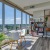 a room with a table chairs and a window with a view of a city
