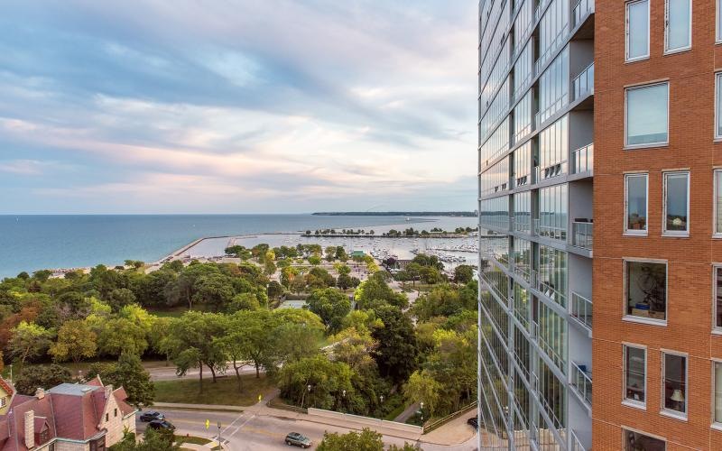 a building with trees and a body of water in the background