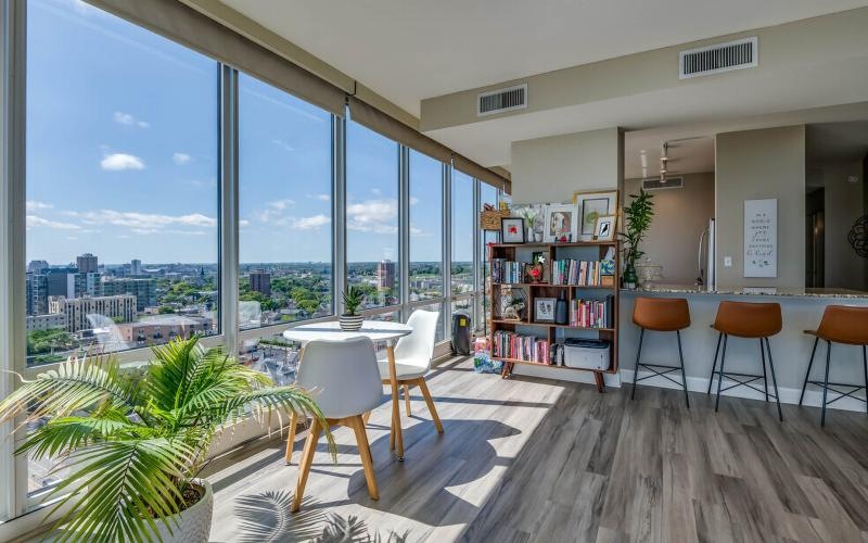 a room with a table chairs and a window with a view of a city